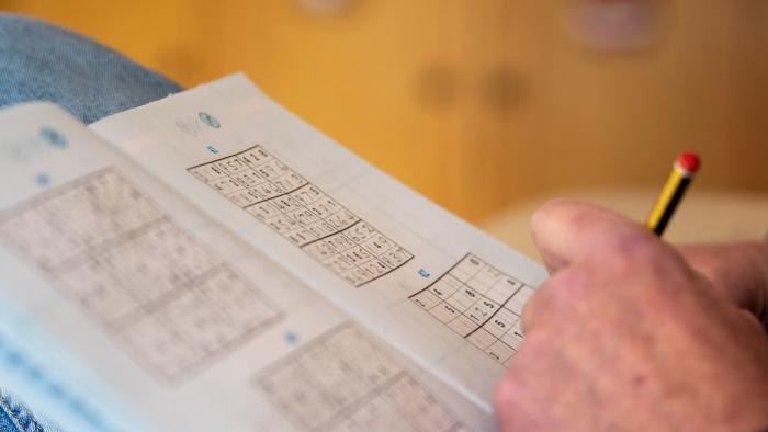 A hand playing Sudoku.