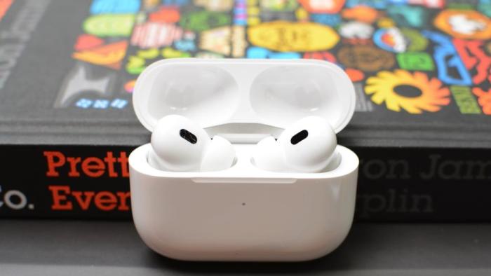 The AirPods Pro 2 with case open, sitting on a pile of books.