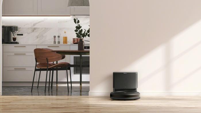 A robot vacuum sits in its dock next to a kitchen.
