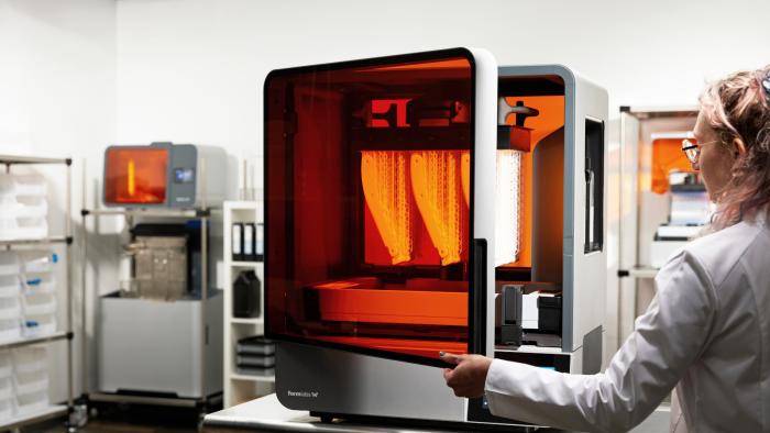 A machine with its door being opened by a person in a white coat.